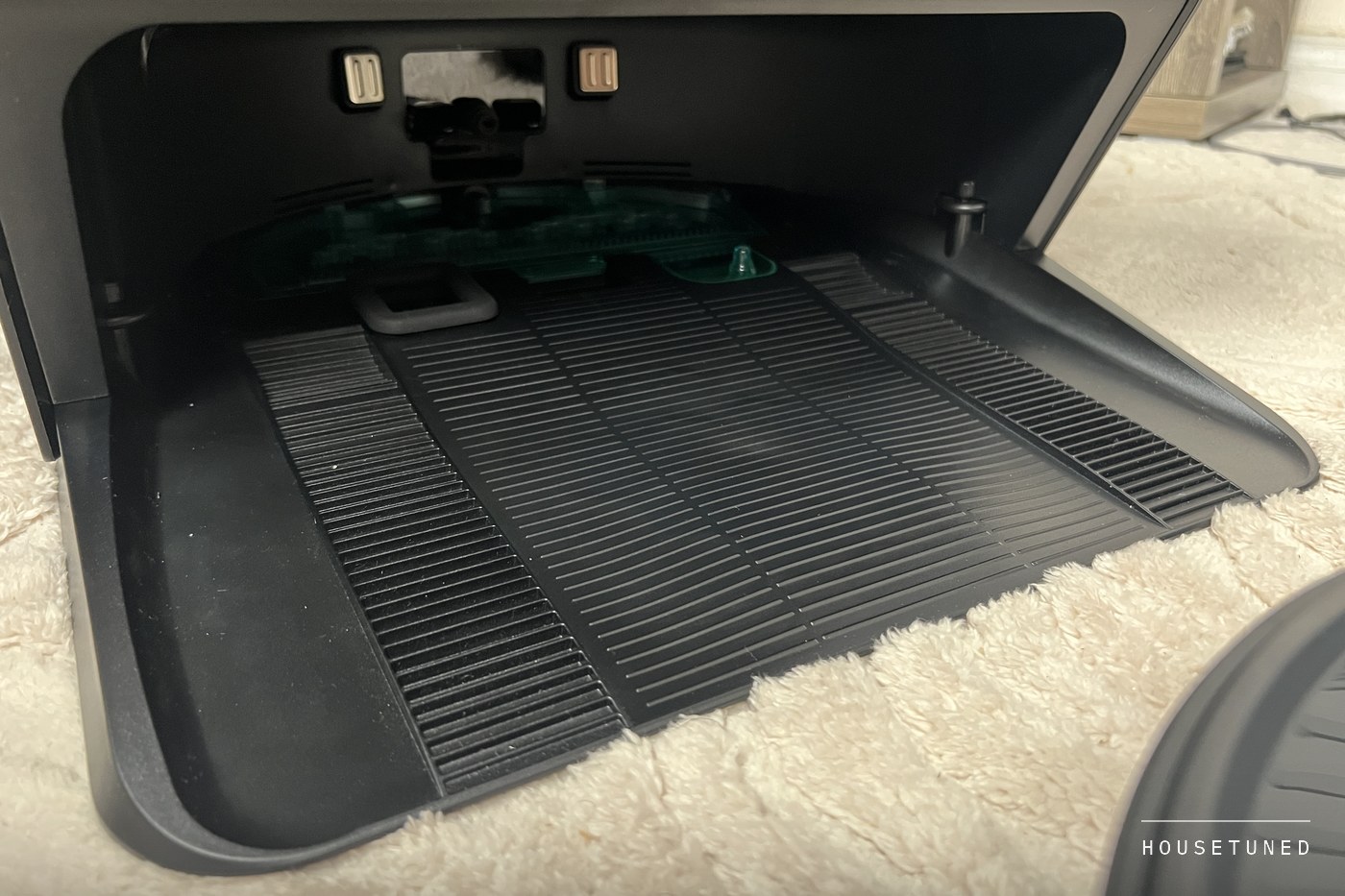 The open base of the Lefant dock with the robot out, showing the ribbed ramp and the roller-washing tray at the back