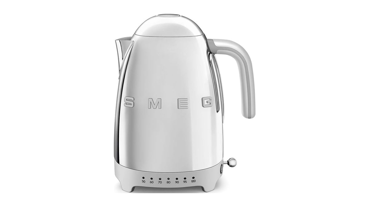 Silver SMEG electric kettle with a rounded lid, side handle, spout, and temperature markings on its base.