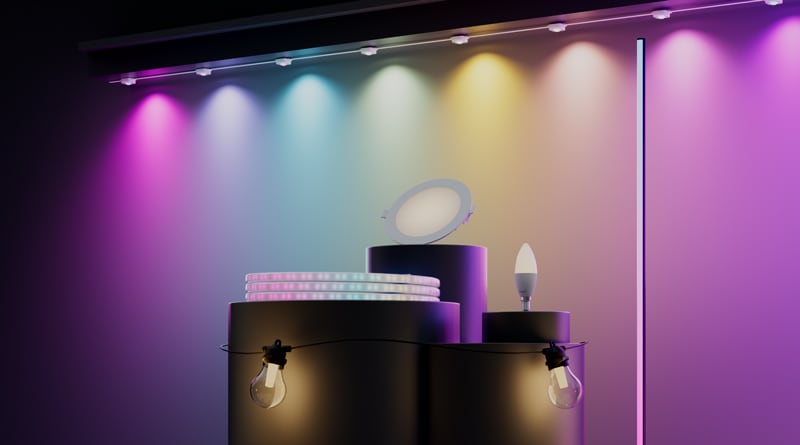 Smart lights displayed on black pedestals beneath a wall washed with multicoloured light.