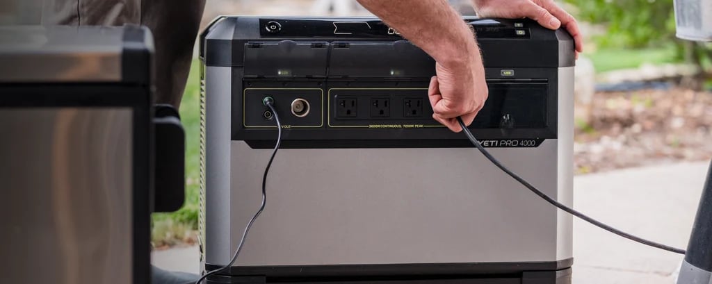 A person handles a cable beside the front outlets of a Yeti PRO 4000 power station.