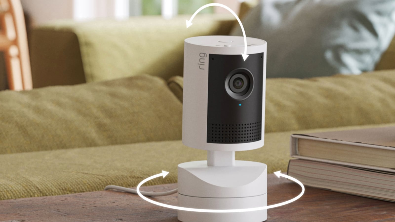 White Ring indoor camera on a table with curved arrows indicating horizontal and vertical rotation.