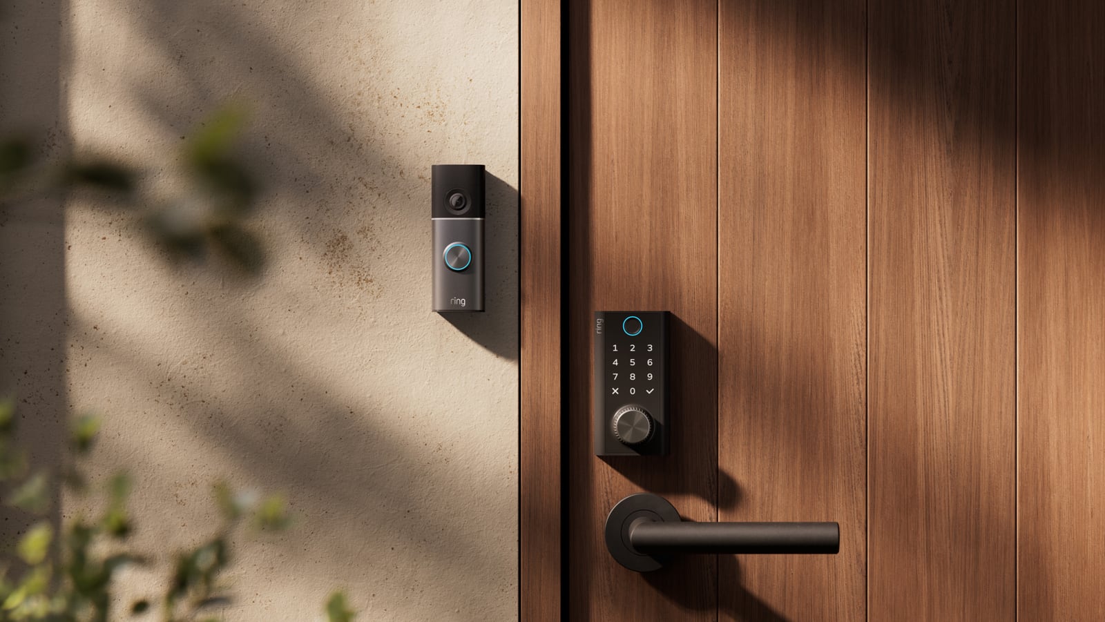 Ring Smart Lock with a keypad and round power dial on a wooden door beside a Ring video doorbell.